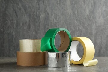 Rolls of different adhesive tapes on grey table