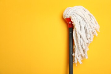 String mop on yellow background. Space for text
