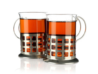 Glasses of aromatic tea in holders isolated on white
