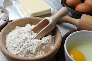 Ingredients for dough and rolling pin on table, closeup