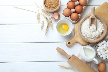 Rolling pin and ingredients for dough on white wooden table, flat lay. Space for text