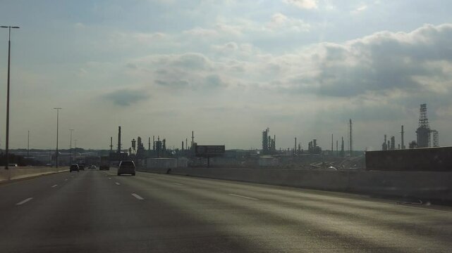 Driving Past Oil Refineries Along the Highway Near a Medical Exit