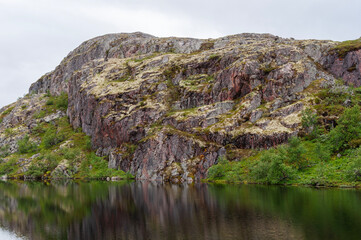 Rocky shore of a small lake in the tundra. Murmansk region, Northern Russia