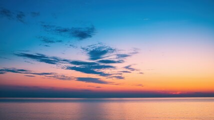 Obraz premium A breathtaking sunset over a calm ocean, featuring vibrant hues of orange and blue, creating a serene and peaceful atmosphere.