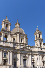Obraz premium The 17th century Baroque church of Sant Agnese in Agone in Piazza Navona against a deep blue sky in Rome, Italy