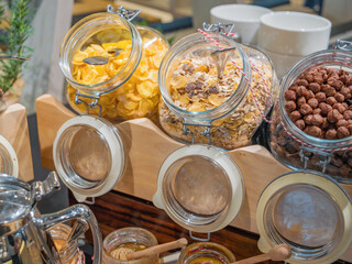 Corn flakes and oat flakes in glass jars are the basis of muesli. Balanced breakfast at the hotel,...