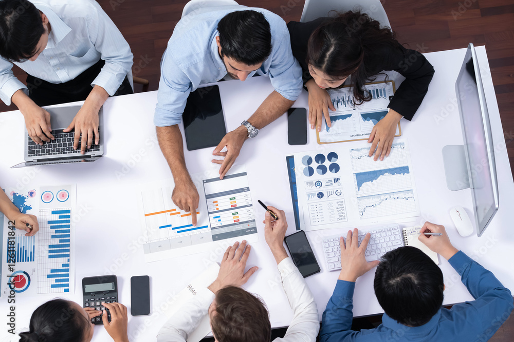 Fototapete Top view analyst team utilizing BI Fintech to analyze financial data at table in meeting room. Analytic BI dashboard power on paper for business insight and strategic marketing planning. Prudent