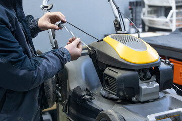 man checking the oil on a lawnmower