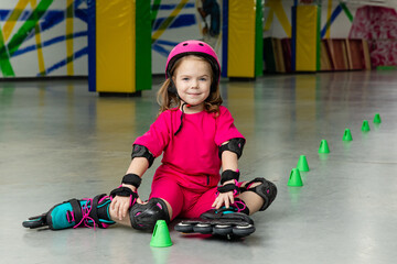 Child skating on roller rink. Roller skating at rollerdrome with cones. Sport and lifestyle...