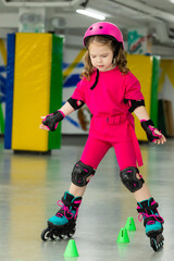 Naklejka premium Child skating on roller rink. Roller skating at rollerdrome with cones. Sport and lifestyle concept. Copy space