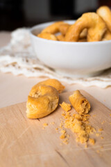 Artisanal homemade typical apulian taralli bowl wooden cutting board, crumbles, baked snack aperitif south italian culture.