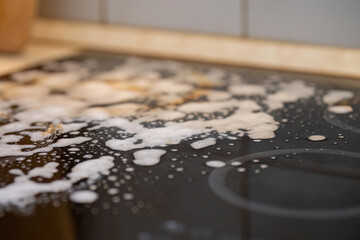 Naklejka premium Cleaning a stovetop with soapy foam and detergent 