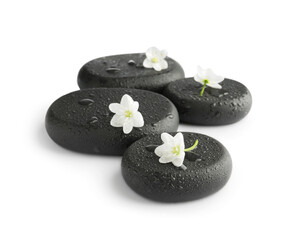 Wet spa stones and beautiful flowers isolated on white