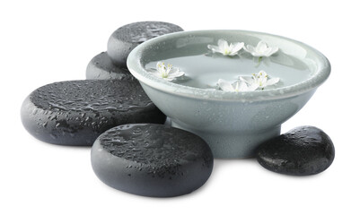 Wet spa stones and bowl of water with beautiful flowers isolated on white