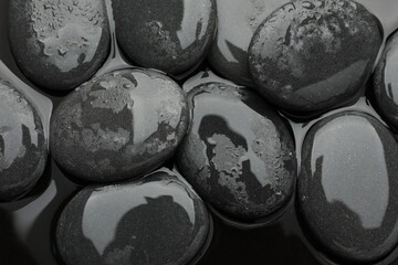Spa stones on water surface, flat lay