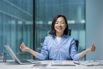 Young joyful Asian woman meditating, resting and relaxing in lotus position. Woman smiling...