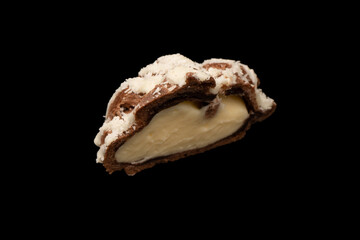 Profiteroles with coconut cream on a black background.