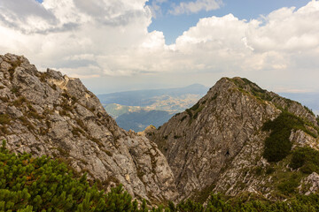 hills and mountain peaks full of vegetation, before summer, under a clear sky full of rain clouds
