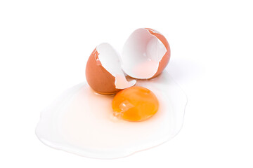 Broken chicken egg with a bright yolk and shell on a white background.