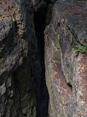 A crevice or cave in the rock dropping downwards into darkness. On the Niagara Escarpment during summer