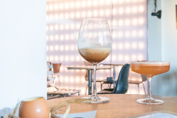 Glass of two Mocktail on table,female hand swirling red wine in wine glass,table for two,Friends cheering with wineglasses,eating and holidays concept.