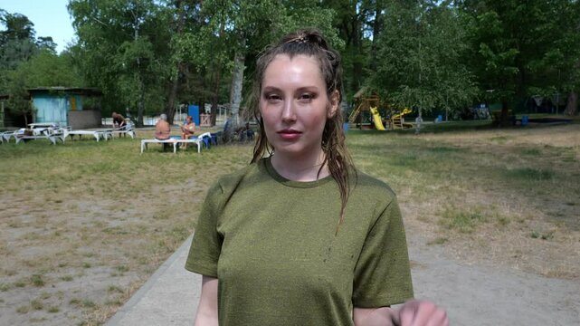 Portrait young woman in green t-shirt in sunglasses walking. Sporty woman. slow motion portrait