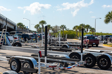 Many empty boat trailers parked a Florida riverside parking lot.