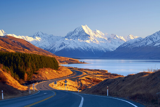 Winding road along Lake Pulaski leading to Mount Cook Village at sunrise, Aoraki Mount Cook National Park, Mackenzie District, Canterbury, South Island, New Zealand