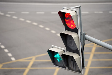 A traffic light with a green light and a red light is on a pole. The red light is lit up,...
