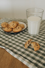 a cozy, inviting scene with a plate of freshly baked cookies and a glass of milk placed beside it