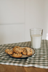 a cozy, inviting scene with a plate of freshly baked cookies and a glass of milk placed beside it