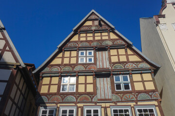 The image shows a half-timbered house with a triangular roof in Bad Salzuflen. The house is located in a European city and is surrounded by other buildings
