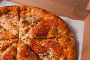 Detail view of some pieces of mozzarella and pepperoni pizza on a cardboard box ready to be delivered.