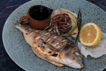 Juicy Grilled Sea Bream with Sauce: Close-up of Fish Served with Lavash, Vegetables and Lemon