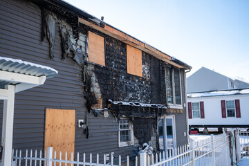 Fire-Damaged House in Winter with Snow-Covered Roof and Exterior Repairs © Siddharth