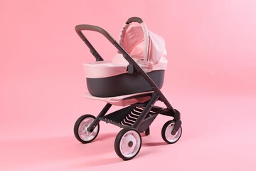 Stylish doll stroller on pink background. Kid's toy