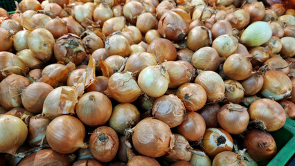 Onions for sale in a supermarket. Onions close-up with selective focus. Vegetables. A pile of onions in the vegetable section of the store