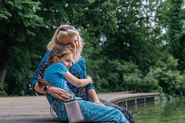 Mother and child sharing a moment by the lake