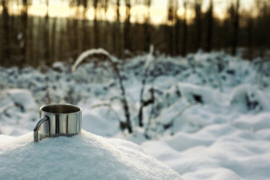 stainless coffee cup in snow