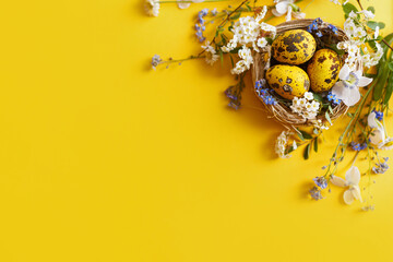 Easter flat lay. Stylish easter eggs in nest and spring flowers on yellow background, space for text. Easter modern minimal banner. Season greetings mockup © sonyachny