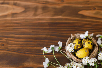 Easter flat lay. Stylish easter eggs in nest and white blossom on rustic wooden background, space for text. Easter rural banner mockup