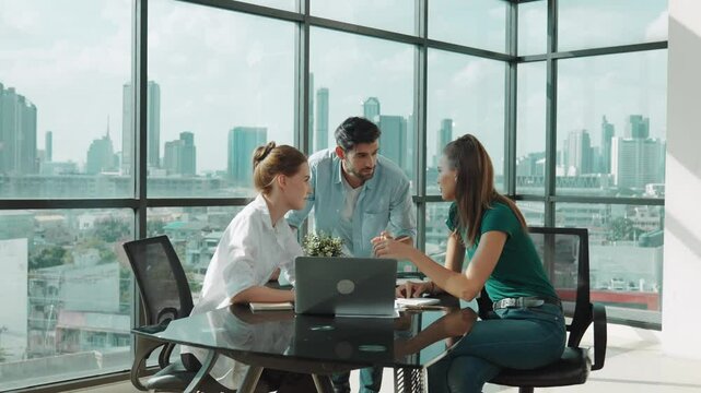 Group of skilled businesspeople sharing idea about marketing plan. Professional business team working together, discussing, talking at meeting table with laptop, document with cityscape. Tracery
