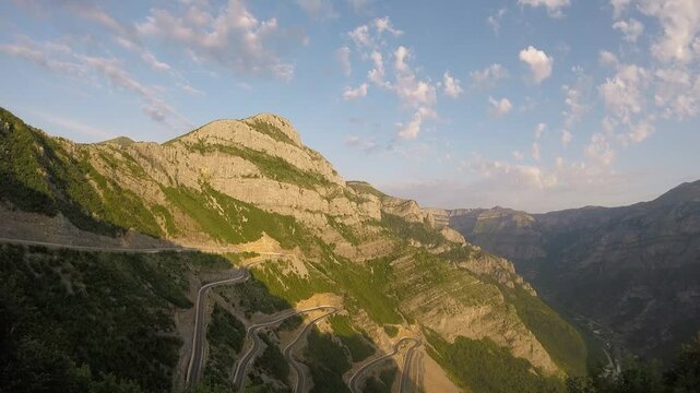 timelapse of epic roads in the north albanian mountains, famous curves and hairpin turns of SH20 road above the Cem river gorge in morning. Sun is just rising over the mountains..