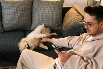 Pomeranian Dog Sitting with Owner on Couch