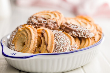 Sweet chocolate cookies in bowl on white table.