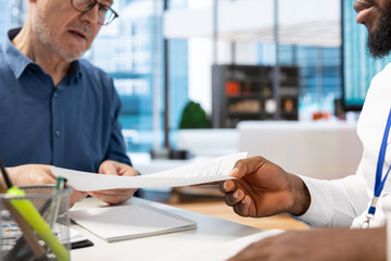 Elderly people obtaining the banking contract with pension plan option, signing a document to...