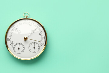 Aneroid barometer on turquoise background