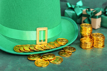 Leprechaun hat with golden coins and gifts on green grunge background. St. Patrick's Day celebration