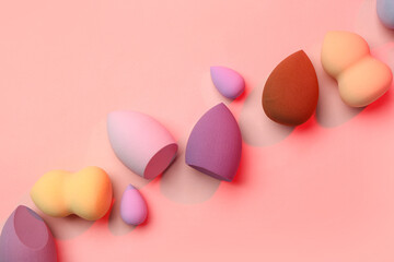 Different makeup sponges on pink background