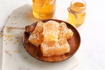 Plate with sweet honeycombs on white background